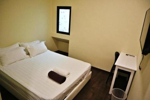 a bedroom with a white bed and a window at Treasure inn hotel in Kota Kinabalu