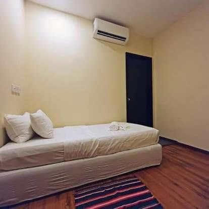 a bedroom with a bed with a air conditioner at Treasure inn hotel in Kota Kinabalu