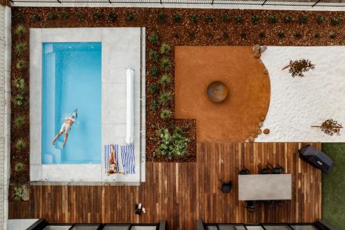 an overhead view of a pool with a swimmer in the water at Le Soleil new villa, golf & heated pool in Dunsborough