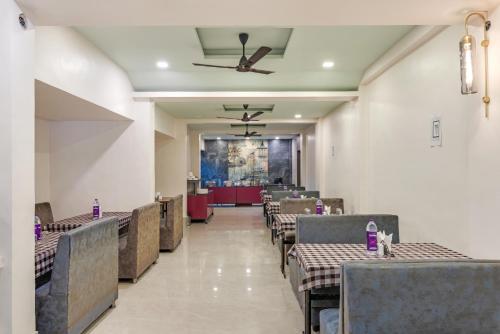 a dining room with tables and chairs and a ceiling at Emerald Retreat in Lonavala