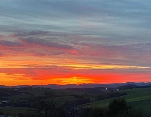a sunset in the sky with mountains in the background at FH Ausblick in Waldkirchen