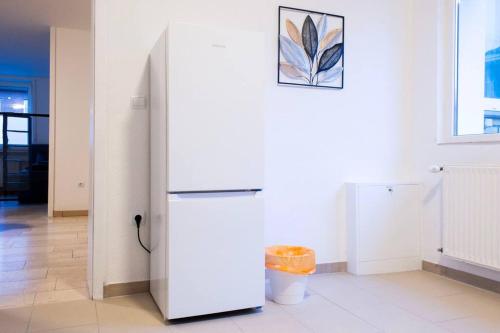 a refrigerator in a room with a picture on the wall at Modernes großräumiges Apartment - zwei Bäder in Gronau