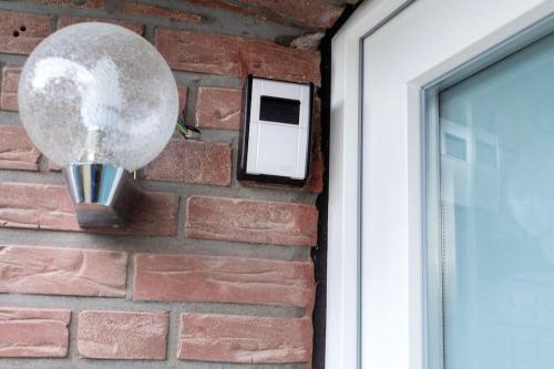 a light on a brick wall next to a window at Modernes großräumiges Apartment - zwei Bäder in Gronau