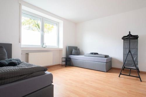 a white room with a bed and a window at Modernes großräumiges Apartment - zwei Bäder in Gronau