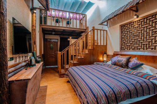 a bedroom with a bed in a room with a staircase at 26Life Ethnic Trail Yunnan Ethnic Creative Inn in Jinghong