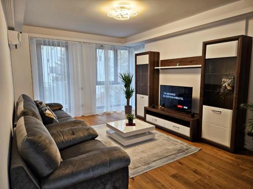 - un salon avec un canapé en cuir et une télévision dans l'établissement Luxury Apartment, à Bucarest