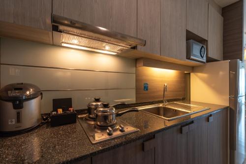 a kitchen with two pots and a sink and a stove at Kantary Hills Hotel, Chiang Mai in Chiang Mai