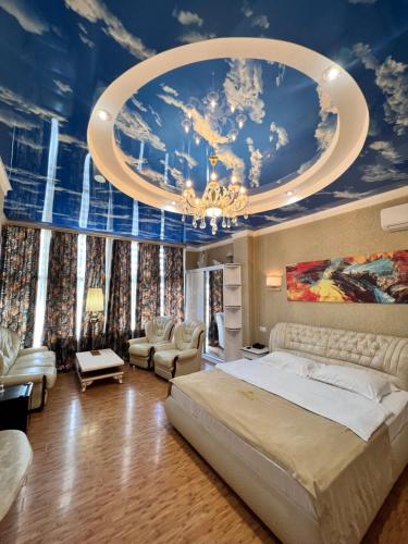Hotel Agava في تبليسي: غرفة نوم بسرير كبير وسقف مع لوحة