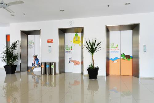 a hallway with three elevators in a building at POP! Hotel Tanjung Karang in Bandar Lampung