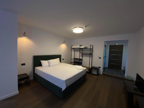 een slaapkamer met een groot bed en een televisie bij HASS Boutique Hotel in Gostivar