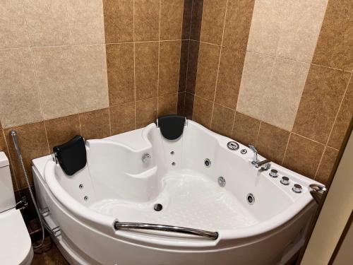a bath tub in a bathroom with a toilet at Hotel Agava in Tbilisi City
