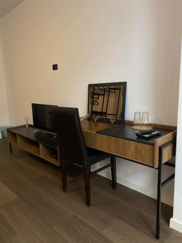 a wooden desk with a chair and a table with wine glasses at HASS Boutique Hotel in Gostivar