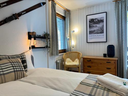 a bedroom with a bed and a desk and a chair at Charming studio, Bettmerhorn view in Bettmeralp