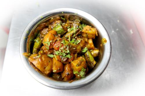 a bowl of food sitting on a white table at Hotel Sharda Residency in Patna
