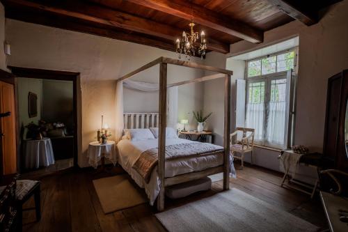 a bedroom with a canopy bed and a window at Moolmanshof 1798, Traditional Cape Dutch H-Shaped Farmhouse in Swellendam