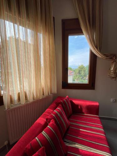 a red couch in a room with a window at Belvedere 1 in Drama
