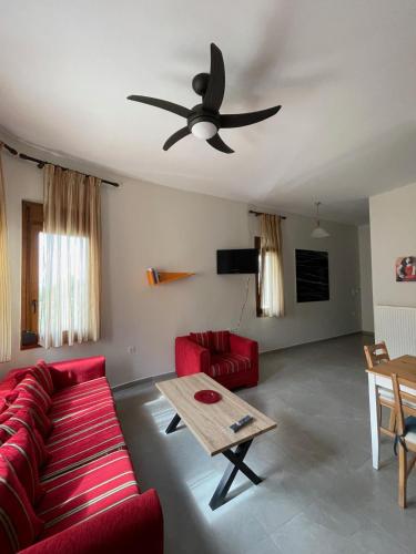 un soggiorno con divano rosso e ventilatore a soffitto di Belvedere 1 a Drama