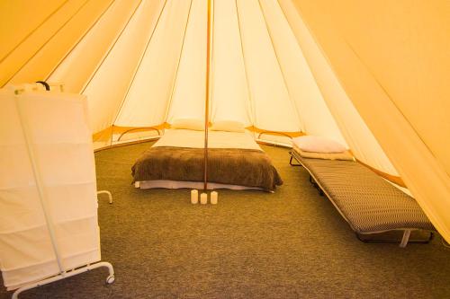 a tent with a bed and a bench in a room at Carul cu Stele-Glamping 