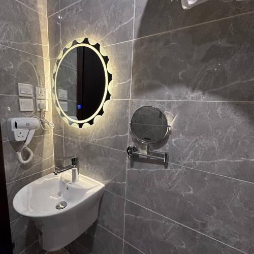 a bathroom with a sink and a mirror at بارك المدينة للشقق المخدومة in Al Madinah