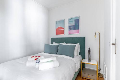 1 dormitorio con cama blanca y cabecero verde en Montaigne/Place de l’Alma : Beautiful Apartment 4P, en París