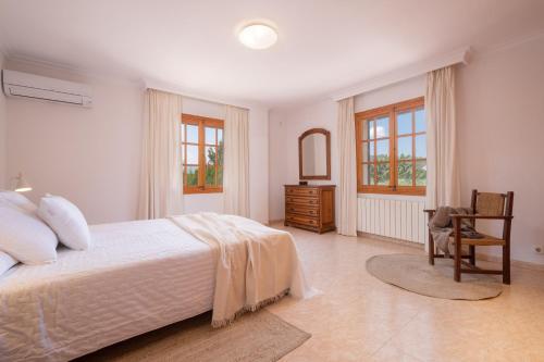 ポリェンサにあるVilla Can Moleto By SunVillas Mallorcaの白いベッドルーム(ベッド1台、椅子付)