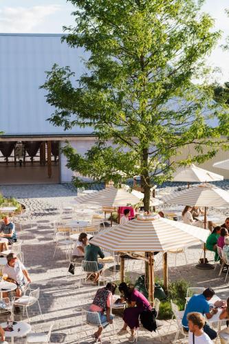 a group of people sitting in chairs under umbrellas at Hopspot in Evergem