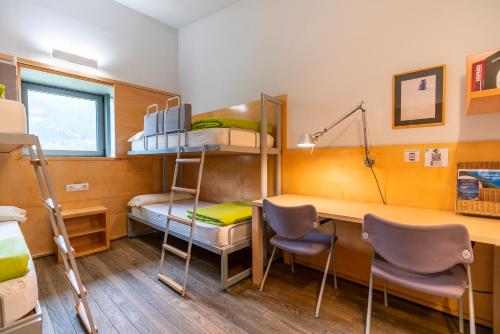 um pequeno quarto com beliches, uma secretária e uma secretária. em MónNatura Pirineus - AJOOO385 em Esterri d'Àneu