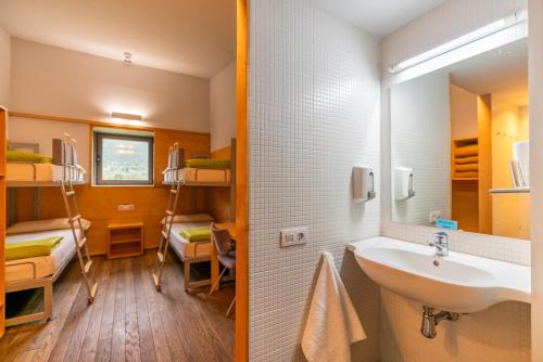 a bathroom with a sink and a bedroom with bunk beds at MónNatura Pirineus - AJOOO385 in Esterri d'Àneu