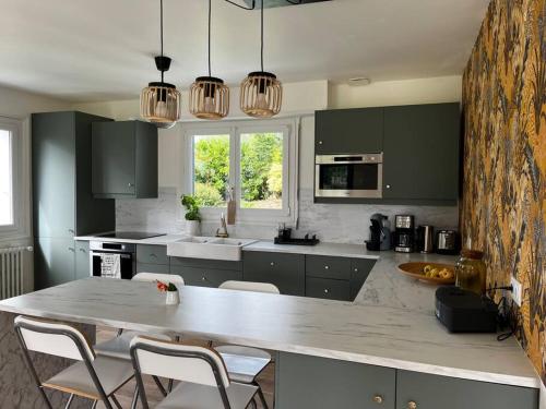 - une cuisine avec une grande table et des chaises dans l'établissement Belle maison proche centre ville et plage (3,5km), à Fouesnant