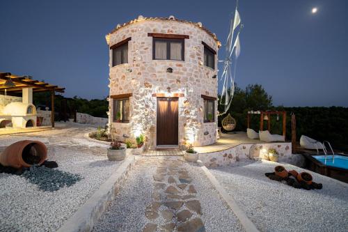a stone house with a door and a swimming pool at Zante Hidden Hills in Ágios Nikólaos