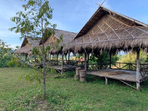 a hut with a bench and a grass roof at ลาน​กางเต๊นท์​ข้าวซอย​เขาค้อ​ in Ban Khao Ya Nua