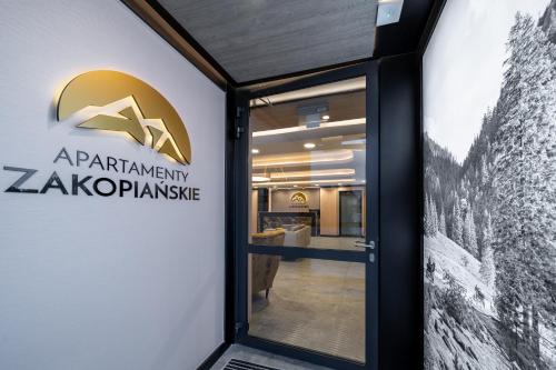 a door to the entrance to the akopkinkin akopkinamine building at RentPlanet - Apartamenty Zakopiańskie in Zakopane
