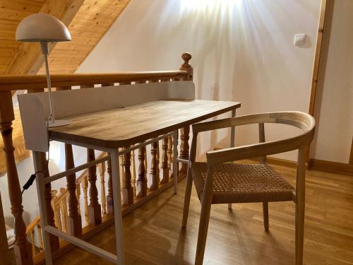 une table en bois et une chaise à côté d'un escalier dans l'établissement Apartamento A10 de Formigal, 9 personas, amplio y garaje, à Escarrilla