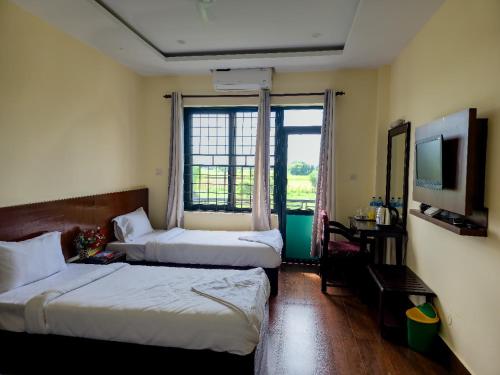 HOTEL OCEAN في لومبيني: غرفة فندقية بسريرين ونافذة