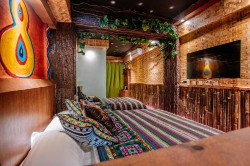 a bedroom with a bed and a flat screen tv at 26Life Ethnic Trail Yunnan Ethnic Creative Inn in Jinghong