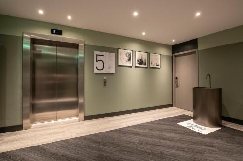 an elevator in a building with the number on the wall at Novotel Luxembourg Kirchberg in Luxembourg