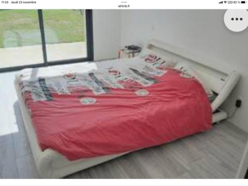 1 cama con edredón rojo en un dormitorio en Maison 24h du Mans et jeux olympiques, en Moncé-en-Belin