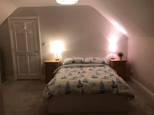 a bedroom with a bed and two lamps on two tables at Cois na Mara Eire code V15 T677 in Bridge of Ross