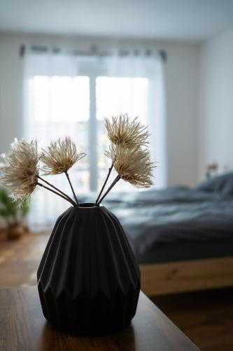 a black vase with dried flowers in it on a table at JS-Apartments in Balingen