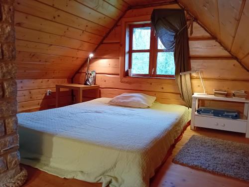 sypialnia z łóżkiem w drewnianym domku w obiekcie Romantiline saunamaja Pädaste lahe ääres w mieście Pädaste