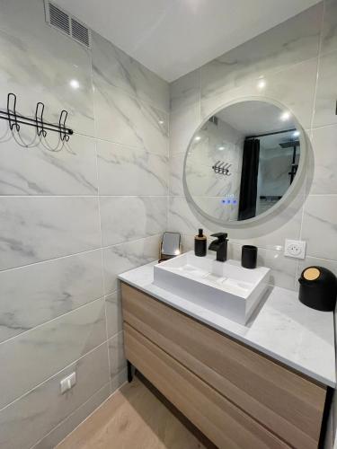 une salle de bain avec un lavabo blanc et un miroir dans l'établissement Family House Vue Mer, à Menton