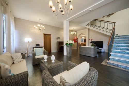ein Wohnzimmer mit einem Kronleuchter und einer Treppe in der Unterkunft Hotel Villa Del Mar in Bibione