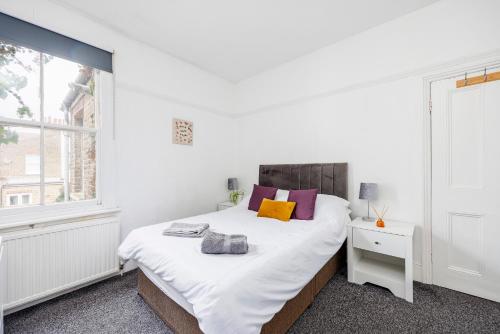 a white bedroom with a bed and a window at City Centre - Bright Apartment - Short & Long stays Everhome by Luxiety Stays in Southend-on-Sea