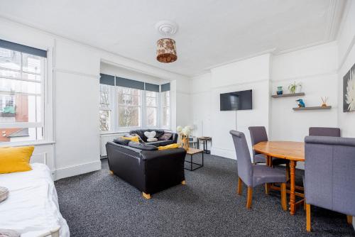 een woonkamer met een tafel en een bank bij City Centre - Bright spacious Apartment - Short & Long stays Everhome by Luxiety Stays in Southend-on-Sea
