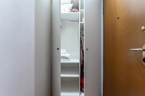 a closet with white shelves and a mirror at Arno River Quiet Apartment in Florence