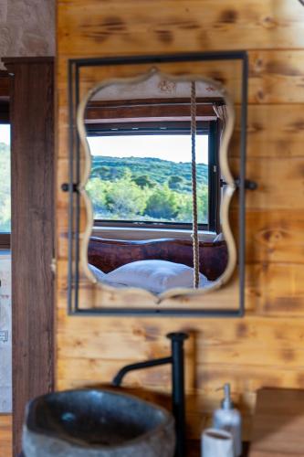 a mirror above a sink in a wooden bathroom at Zante Hidden Hills in Koiliomenos