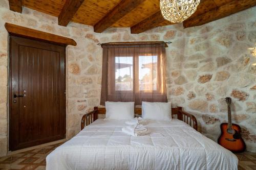 Schlafzimmer mit einem Bett mit Gitarre in der Unterkunft Zante Hidden Hills in Ágios Nikólaos