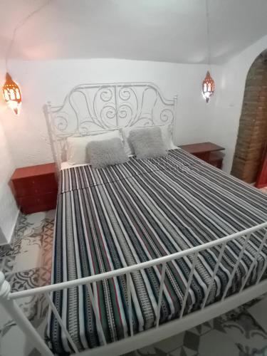 Cama blanca en habitación con 2 almohadas en Cueva La Ermita II, en Guadix