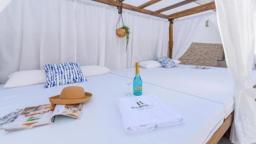 dwa łóżka w namiocie z butelką i kapeluszem w obiekcie Villa Yules-Moisés Vélez-Málaga by Ruralidays w mieście Vélez-Málaga