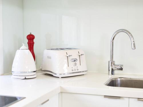 a toaster sitting on a kitchen counter next to a sink at Emerald lakes 3 level villa in Gold Coast